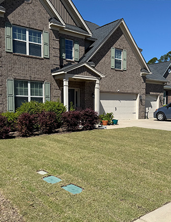 Brick home with well-maintained lawn and stone walkway