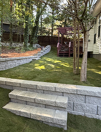 Curved retaining wall and lawn in shaded backyard