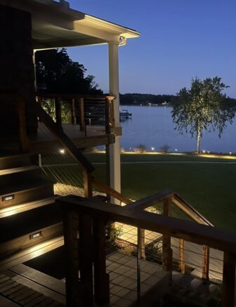 Backyard deck at night with lake view and soft lighting
