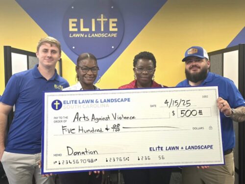 Donation check presentation with Elite Lawn & Landscape team