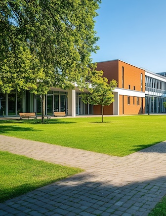 Modern building with green lawn and walkway.