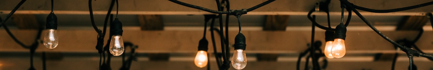 Hanging vintage string lights w on a wooden pergola beams patio in a backyardith edison bulbs