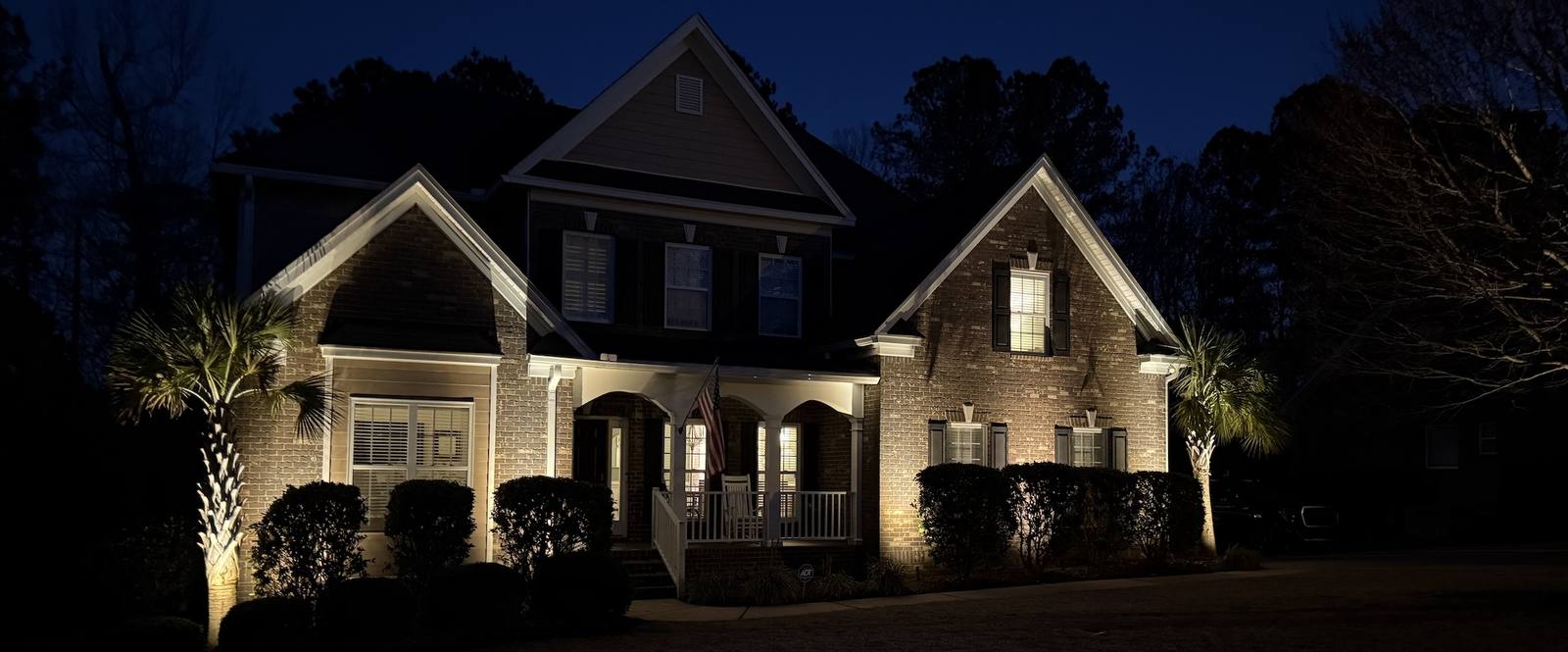 House front illuminated by outdoor landscape lighting