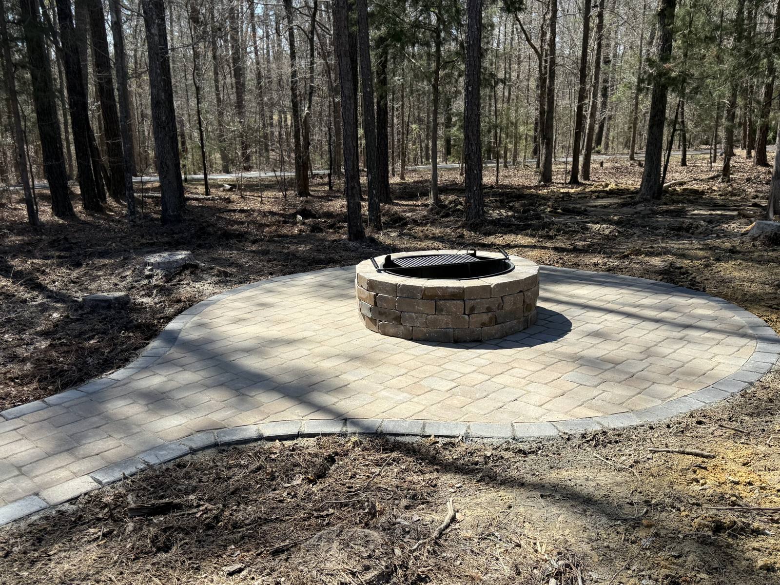 Fire pit area in shaded wooded landscape