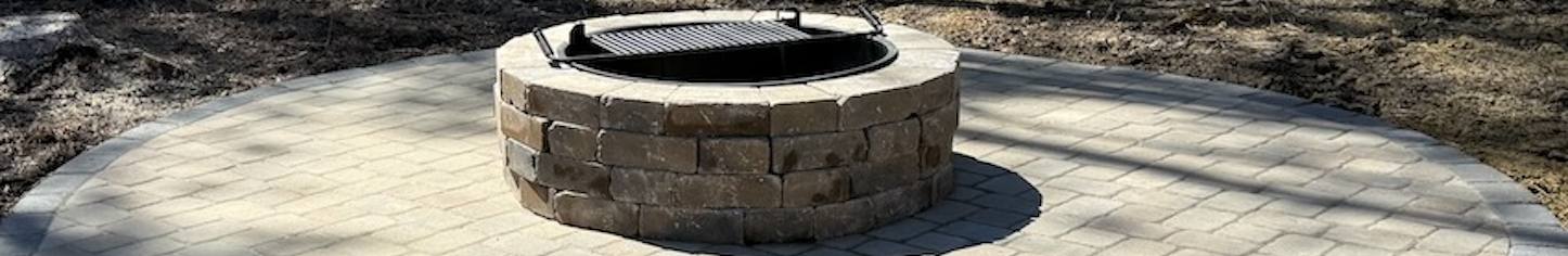 Circular stone fire pit on a paved patio