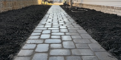 Stone paver pathway with dark mulch edges