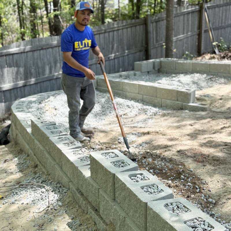 Worker leveling block wall installation