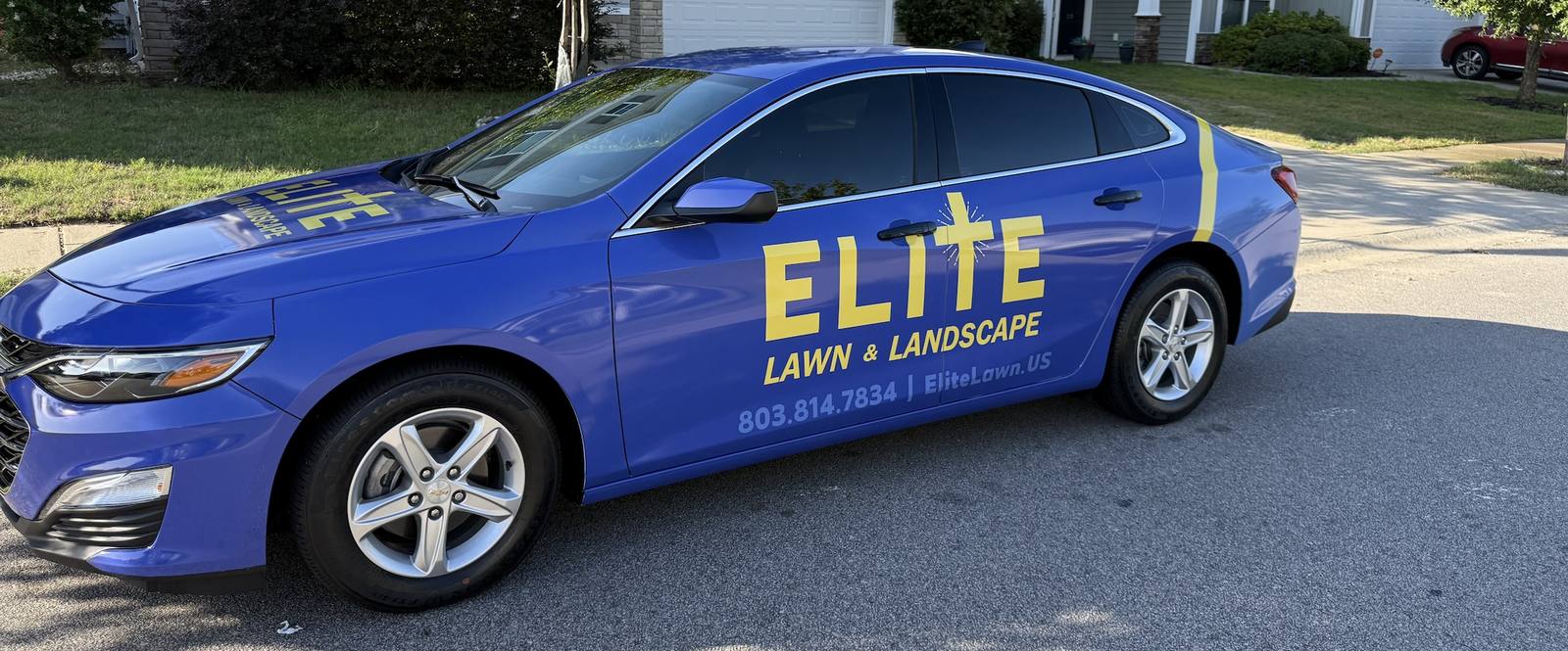 Elite Lawn & Landscape branded blue vehicle