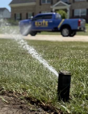 Sprinkler system running on green lawn