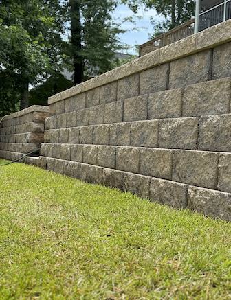 Newly built block retaining wall beside grassy slope