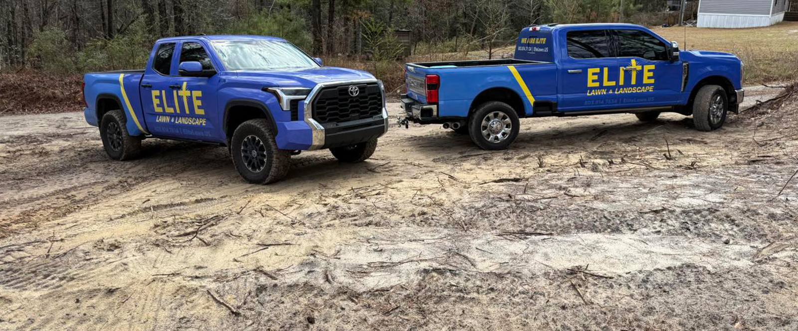 Blue Elite Lawn trucks parked on job site