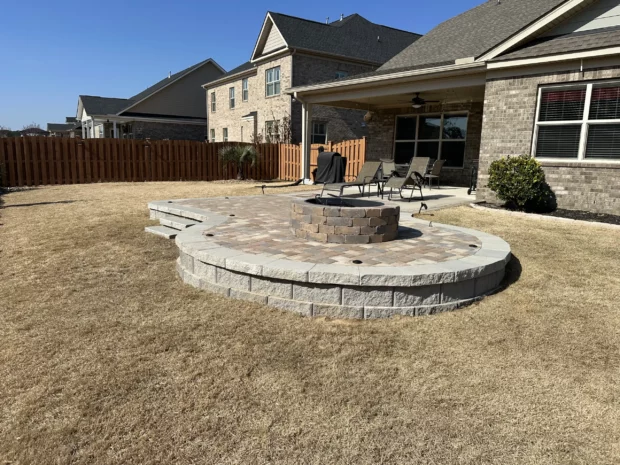 Circular paver patio with fire pit in dry lawn