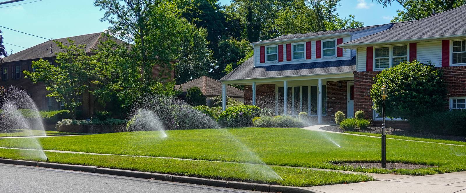 Residential sprinkler system watering front yard
